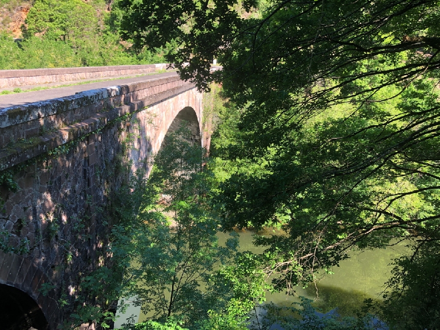 Traversez le pont de Coursavy qui enjambe le Lot entre les département du Cantal et de l'Aveyron