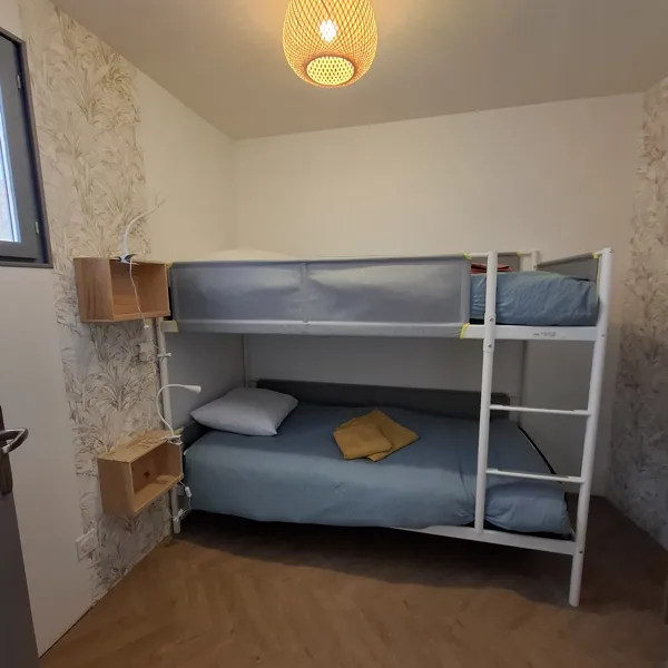 la petite chambre avec lit superposé, colonne de rangement pour les vêtements, et petit bureau